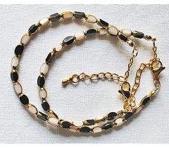 Armband facetgeslepen zwart en wit met goudkleur kralen 5x3mm