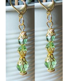 Oorbellen Swarovski facetgeslepen kralen Peridot groen met goudkleurige kralenkapjes