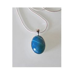 Schuin gestreepte blauwe agaathanger aan zilverkleurige ketting.