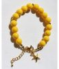 Armband 10mm gele acryl kralen met bedeltje. 18cm + verlengketting